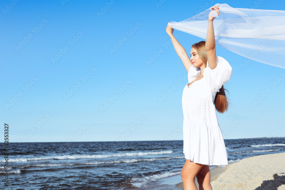 Happy blonde woman is catching clouds and wind with her arms on the ocean beach. Happy blonde woman is catching clouds and wind with her arms on the ocean beach.