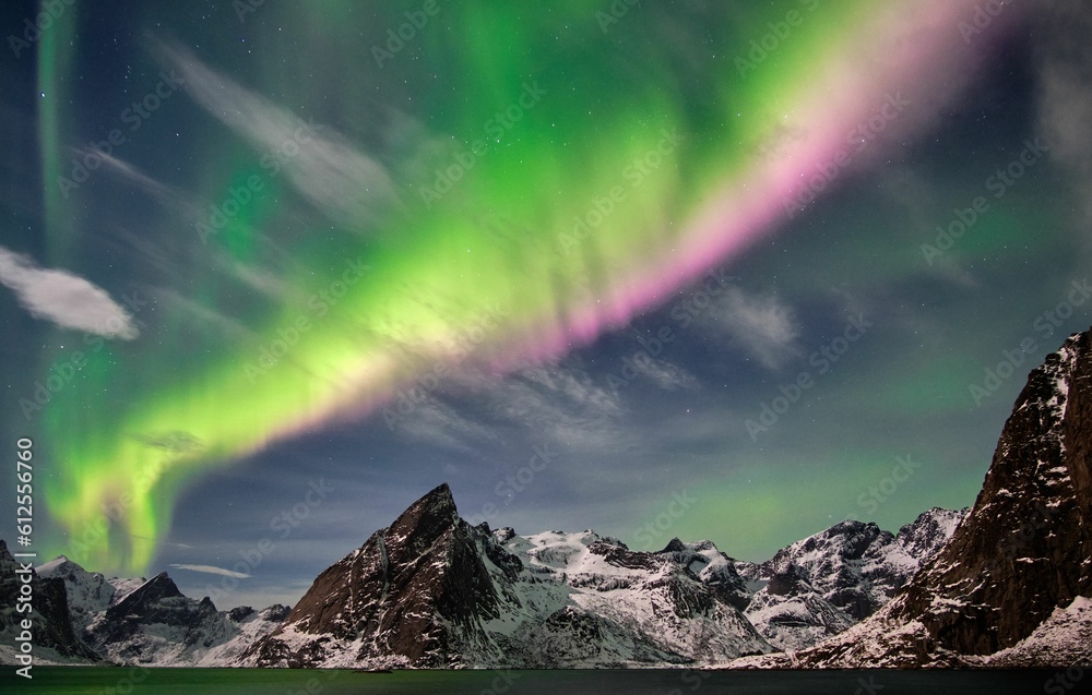 Scenic view of the Northern lights of Norway in the sky behind the rock formations