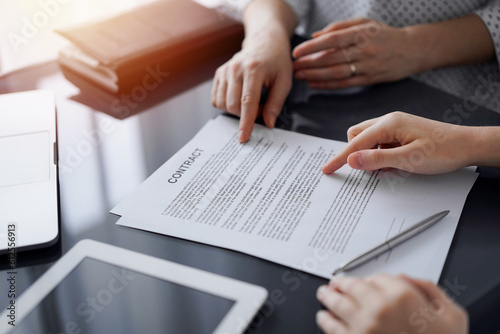 Business people discussing contract signing deal while sitting at the glass table in office, closeup. Partners or lawyers working together at meeting. Teamwork, partnership, success concept.