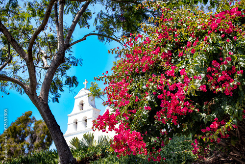 Bright Pink Bougainvillea Flowers Bloom and Contrast against a Bright Blue Sky at the White Façade of the Mission Basilica San Diego de Alcala in San Diego, California, USA