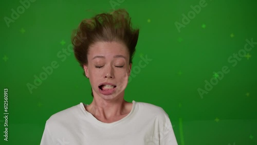 Caucasian girl in front of TV screen getting blown away. Cinema concept with chroma key.