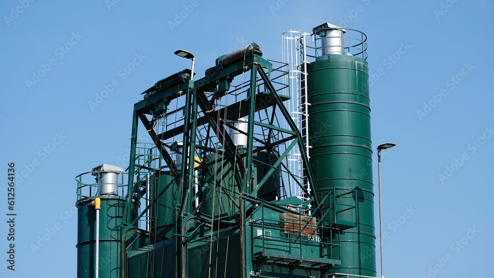 Closeup shot of a cement factory under a blue sky Closeup shot of a cement factory under a blue sky