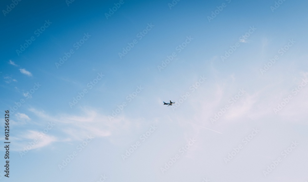 Low angle shot of a plane flying in a blue sky