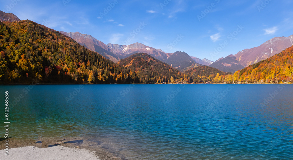 beautiful fairytale landscape in autumn with mountains in the background and a blue lake with the perfect sky