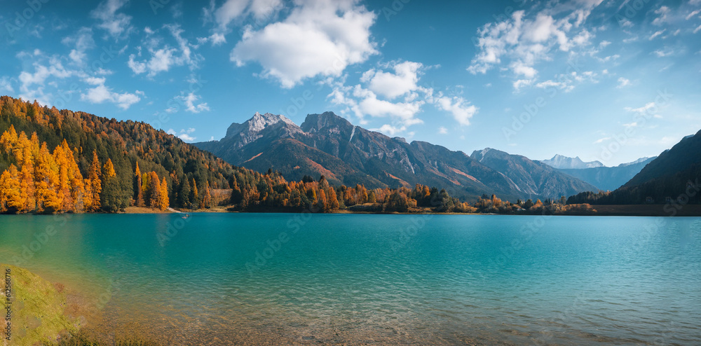 beautiful fairytale landscape in autumn with mountains in the background and a blue lake