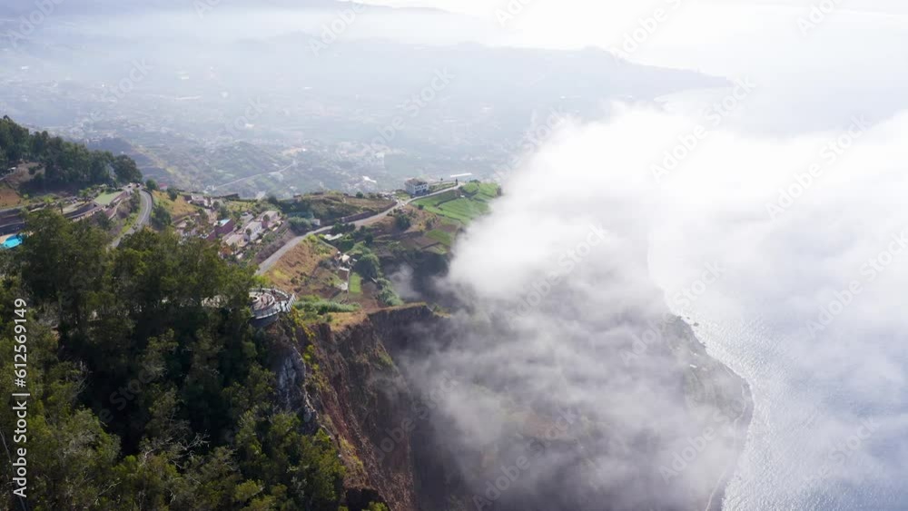 Aerial view of a town on a cliff on a foggy day in Madeira Island Aerial view of a town on a cliff on a foggy day in Madeira Island