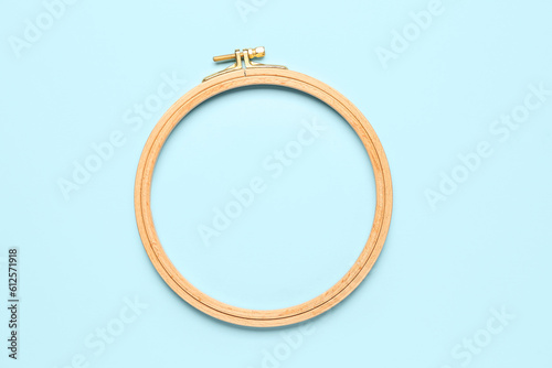 Wooden embroidery hoop on blue background
