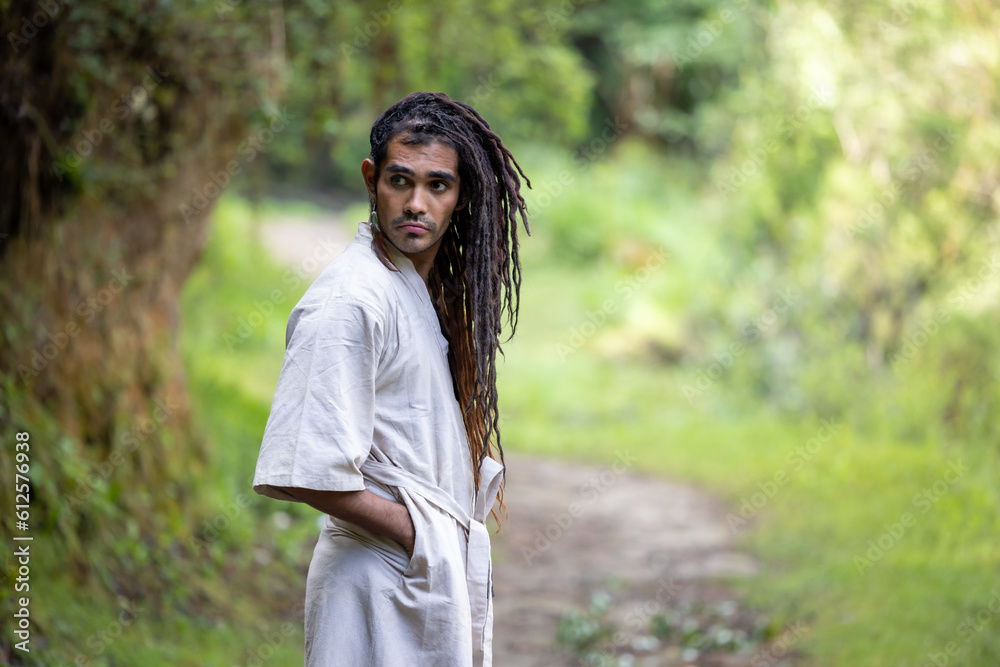 portrait of a young, attractive, dark-skinned latin man with bohemian style, hipster, fashion with dreadlocks and tunic in the woods portrait of a young, attractive, dark-skinned latin man with bohemian style, hipster, fashion with dreadlocks and tunic in the woods
