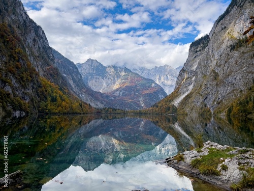 Landscape view of Obersee Lake in Germany under rocky mountains and blue cloudy sky