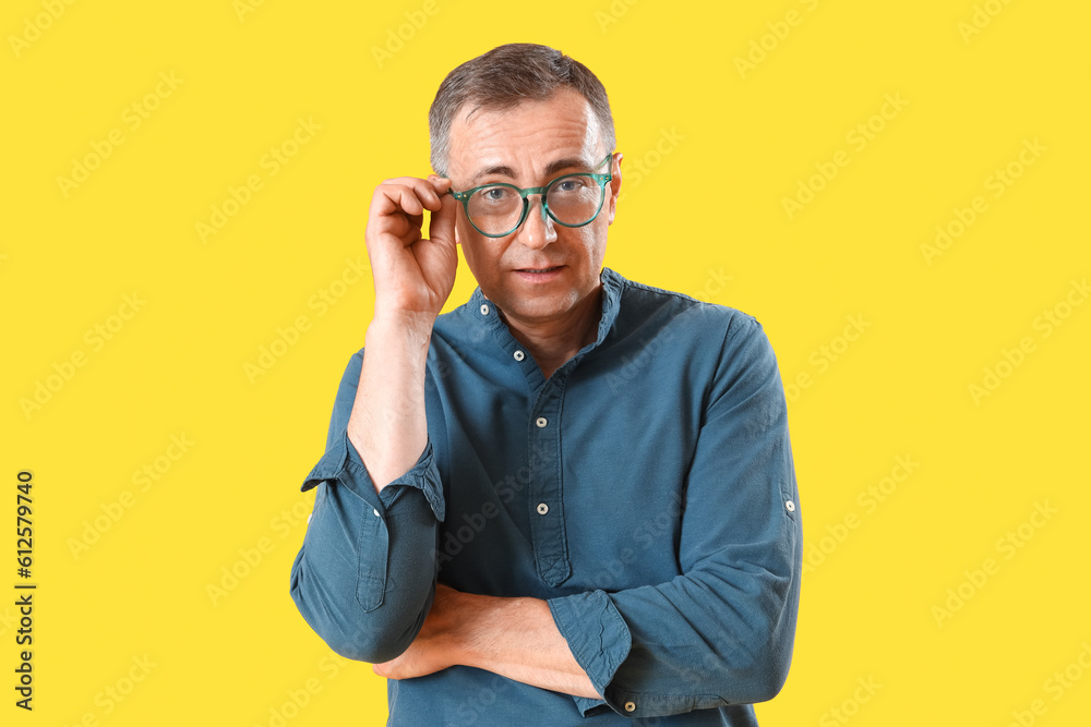 Mature man in eyeglasses on yellow background Mature man in eyeglasses on yellow background