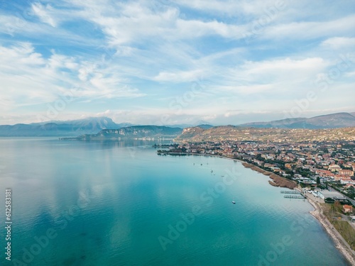 Aerial view of an ocean coast surrounded by a mountain range and a small village