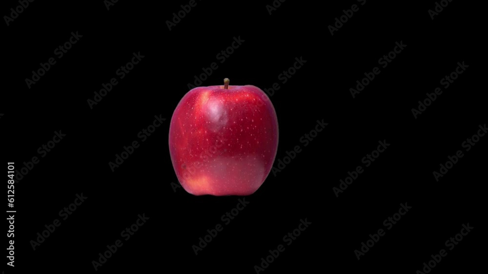 Closeup of the illuminated spinning red apple isolated on a black background