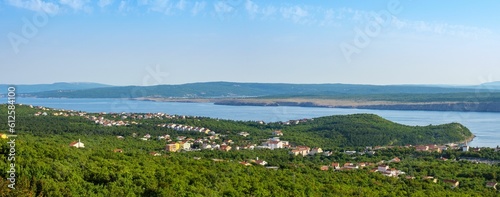 Panoramic shot of a coastline covered with dense green vegetation