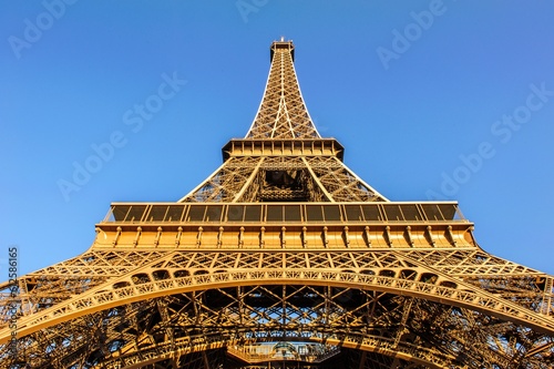Low angle shot of the Eiffel tower on the background of the bright blue sky © Charel Schreuder/Wirestock Creators