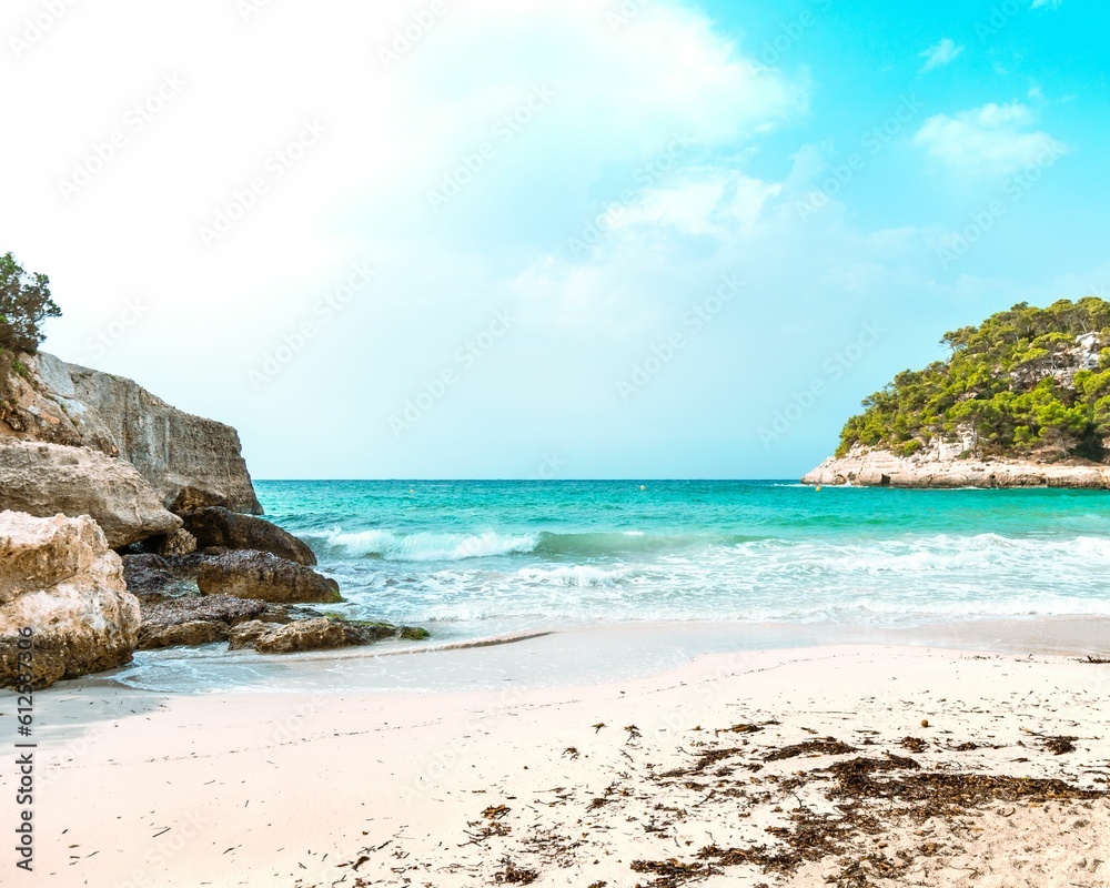 Landscape of the Minorca beach surrounded by greenery on a sunny day in Spain