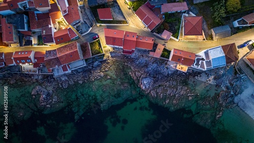 Drone shot of colorful houses on the rocky coast of Corrubedo natural park in Galicia, Spain photo