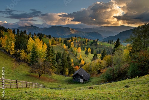 Beautiful shot of a wooden cabin house on the mountainside with the background of forest mountains