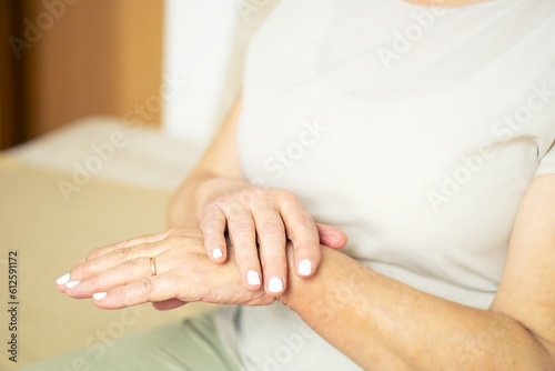 Close up of senior woman appllying hand cosmetic cream at home.
