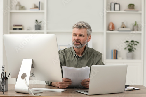 Professional accountant working at wooden desk in office