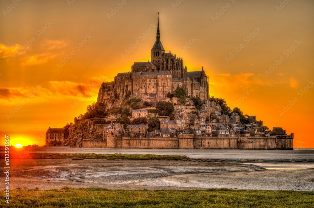 Scenic view of the Abbey located on Mont Saint Michel with a beautiful sunset in the back