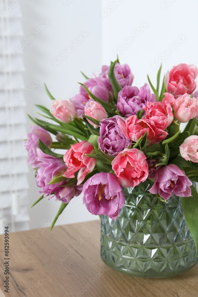 Beautiful bouquet of colorful tulip flowers on wooden table indoors Beautiful bouquet of colorful tulip flowers on wooden table indoors