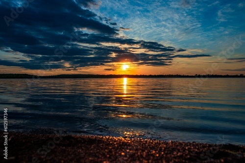 Landscape shot of Holden Lake reflecting the beautiful sunset light coming from behind the clouds