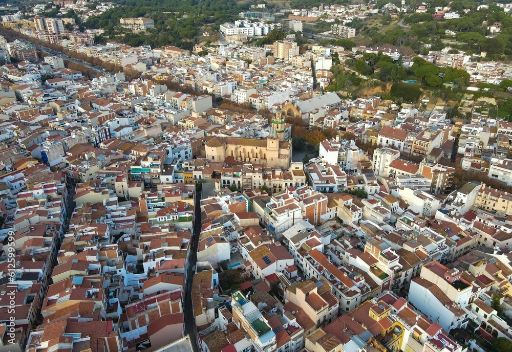 Aerial drone view of a big city with red-roofed houses during the daytime