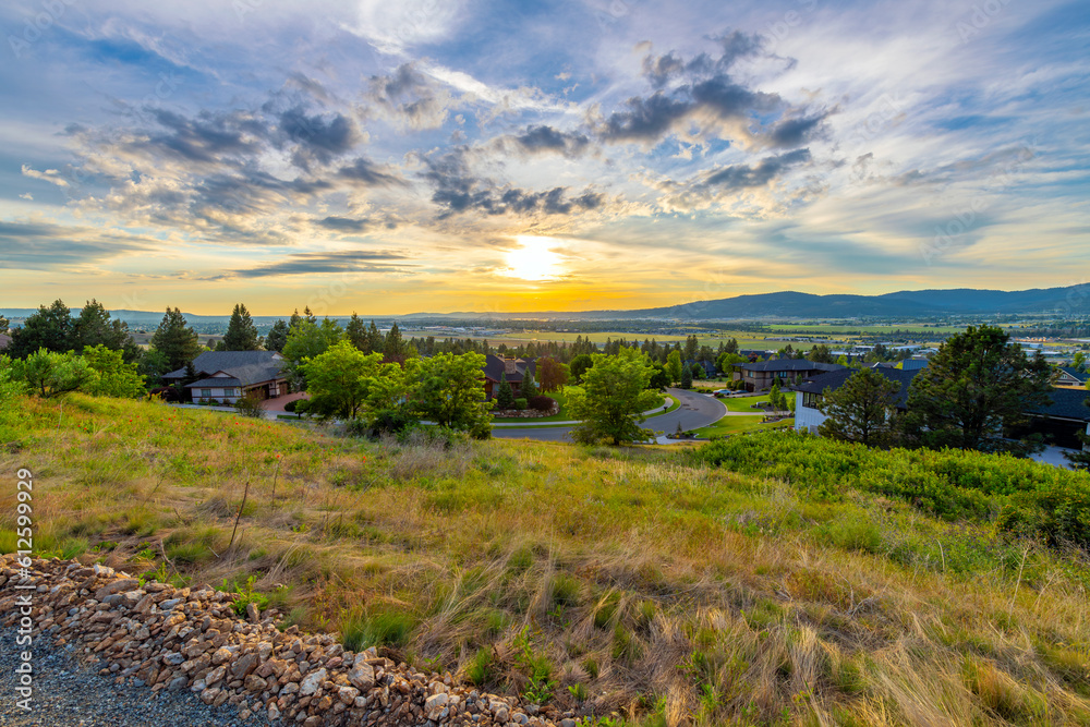 Late afternoon sunset view from a hillside above a subdivision of homes of the cities of Liberty Lake, Spokane and Spokane Valley, Washington.