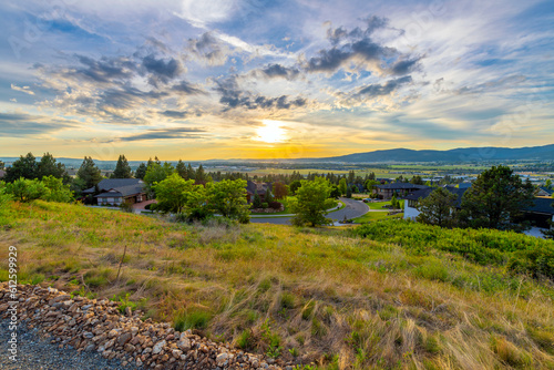 Late afternoon sunset view from a hillside above a subdivision of homes of the cities of Liberty Lake  Spokane and Spokane Valley  Washington.