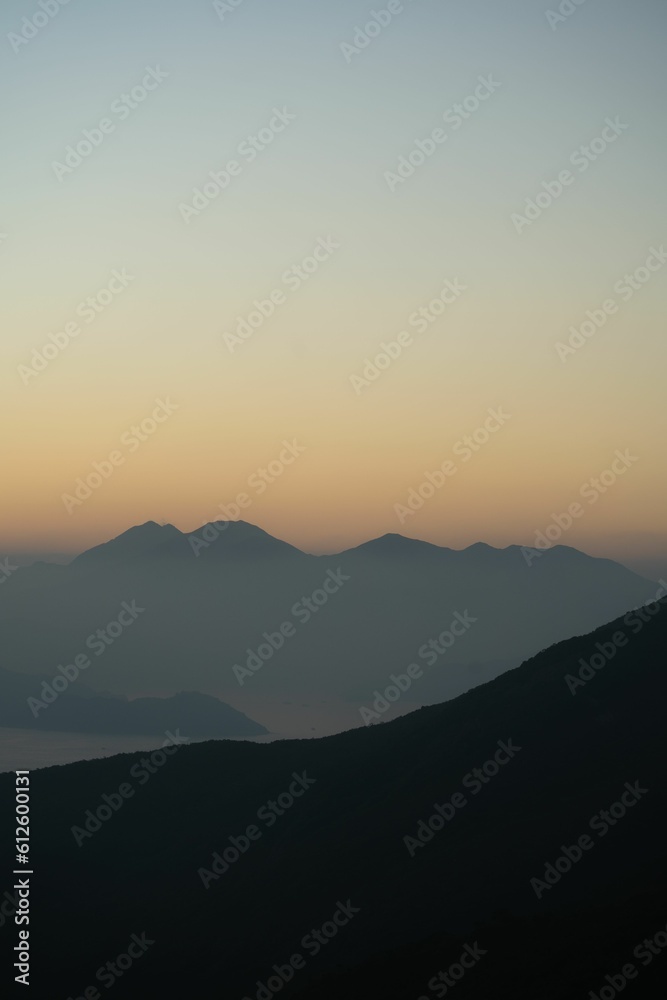 Vertical shot of mountain silhouettes during a sunset