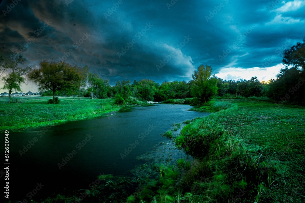 Beautiful river in a meadow with a dramatic cloudy sky in the background, Waco, Texas, United States