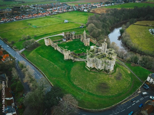Aerial view of Warkworth Castle surrounded by green vegetation photo