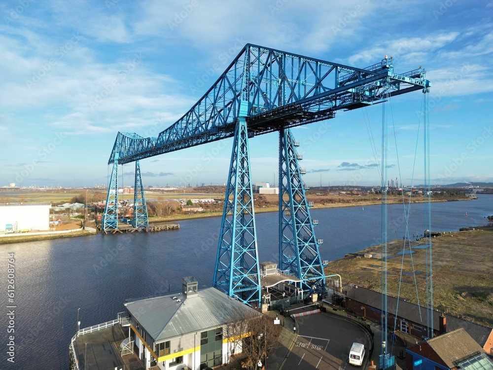 Drone shot of tees transporter bridge over the sea in a port under blue cloudy sky Drone shot of tees transporter bridge over the sea in a port under blue cloudy sky