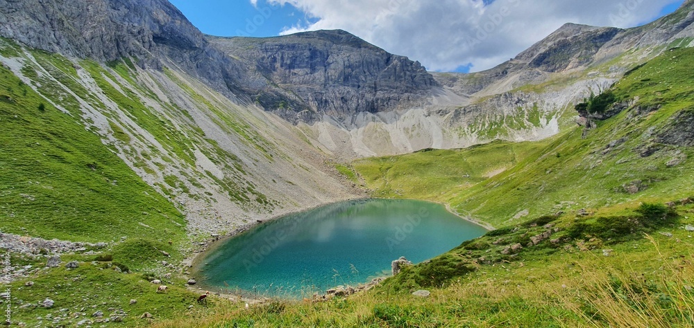 Scenic view of a small lake located in a valley surrounded by mountains