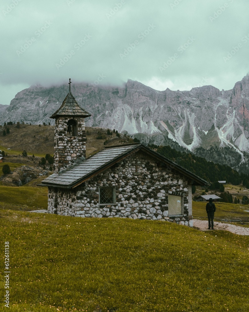 Vertical shot of a lonely house in the mountains on a cloudy day Vertical shot of a lonely house in the mountains on a cloudy day
