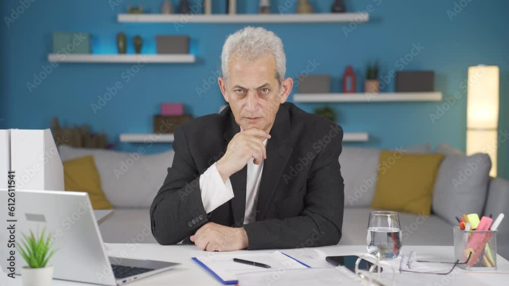 Home office worker man looking at camera with a stern angry warning.