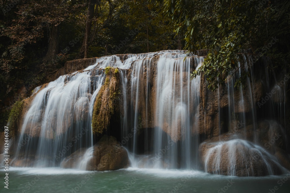 Closeup of a magical waterfall stream on big textured rocks in a forest