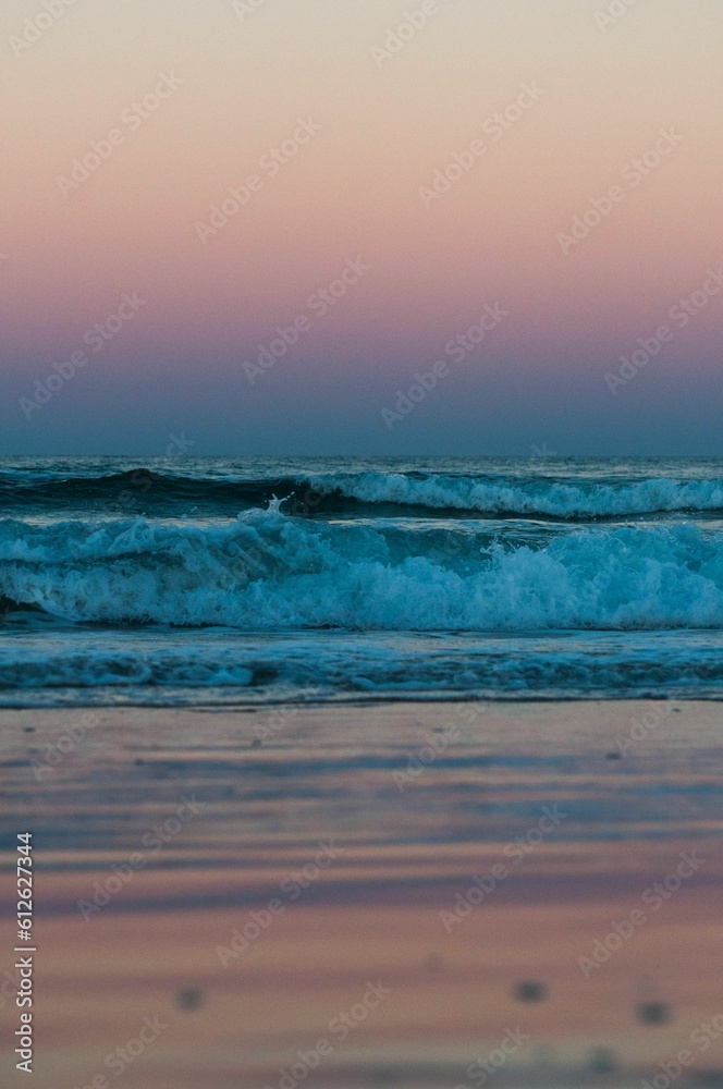 Obraz premium Vertical shot of a beautiful sea during the sunset