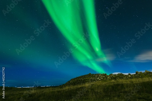 Landscape of a field with northern lights in the background at night