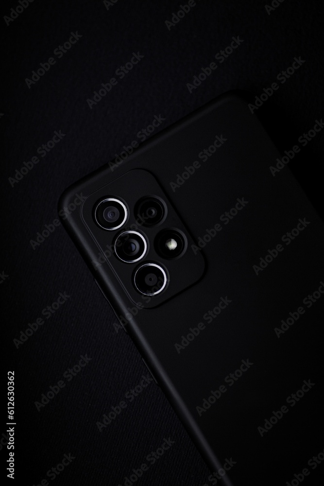 Closeup of rear of the Samsung Galaxy A53 with a black case on the dark background