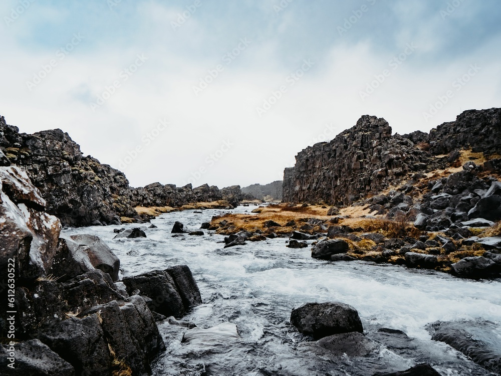 River flowing between rocky formations with a gloomy skyscape in the background