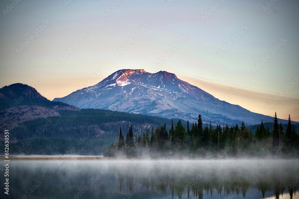 Foggy Sparks Lake at sunrise reflecting a snowy mountain and clear sky background