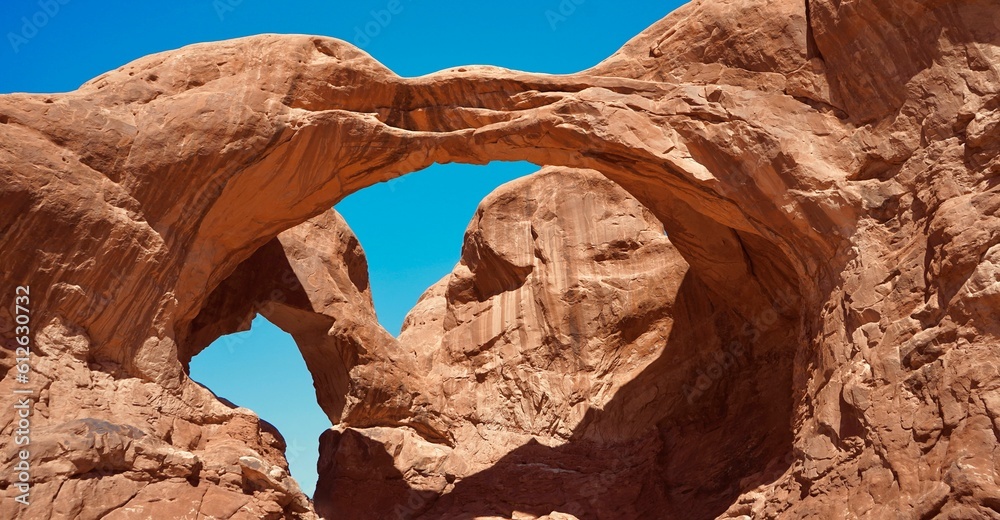 Low angle shot of Double Arch against blue sky in Grand County, Utah