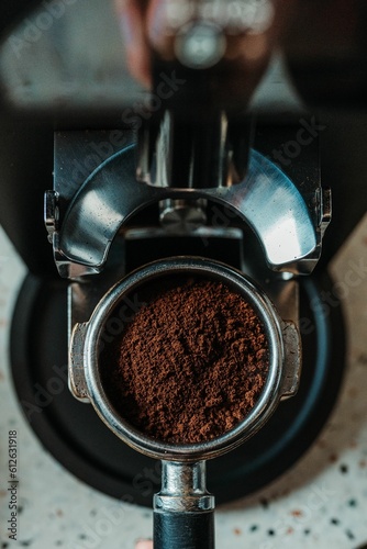 Vertical top view of a coffee tamper filled with fresh brown powder