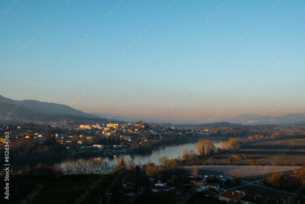 Scenic view of a valley from the top of a hill, overlooking a cityscape and body of water