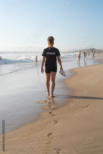 Athletic sport coach walking alone on the beach photo