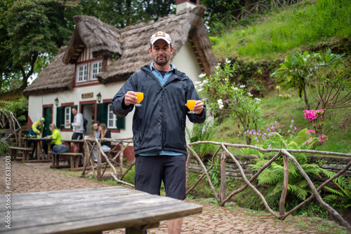 Man hiking in Madeira Island carrying Poncha drinks photo