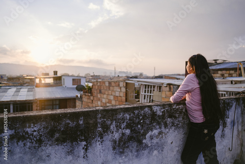 Woman leaning on rooftop wall admiring The view