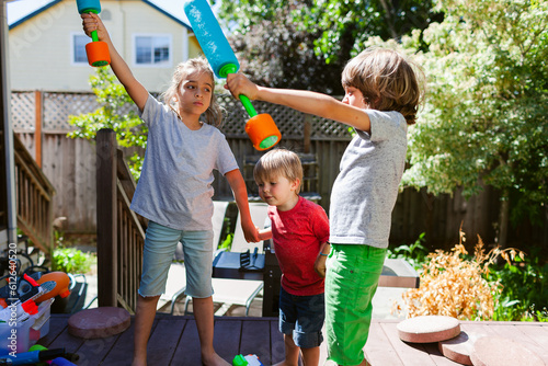 Kids playing with water guns at garden photo