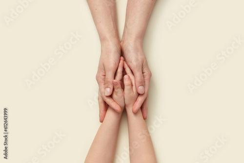 Supporting mother's hands holding little kid's hands. photo